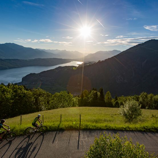 zwei Radfahrer auf erhöhter Straße über See