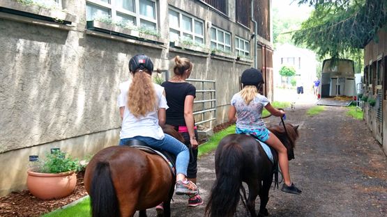 Kinder reiten auf Ponys